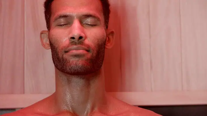 close up of a man in a jacuzzi infrared sauna with red light