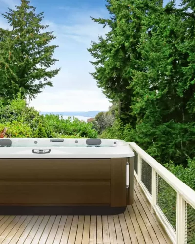 jacuzzi j-375 hot tub installed on deck and near forest for natural setting